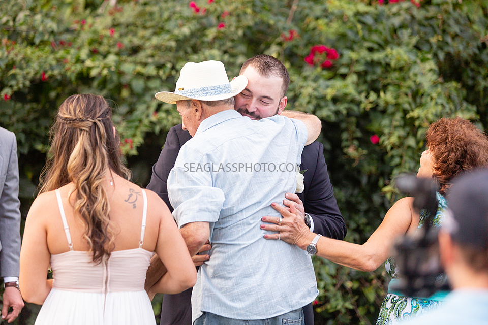 Groom and Father of the Bride embrace after walking the bride up the aisle in Vero Beach Florida