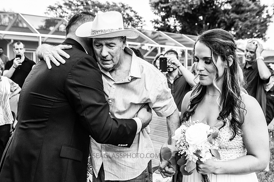 Black and White Groom embraces the Father of the bride after he walked the bride up the aisle in Vero Beach Florida