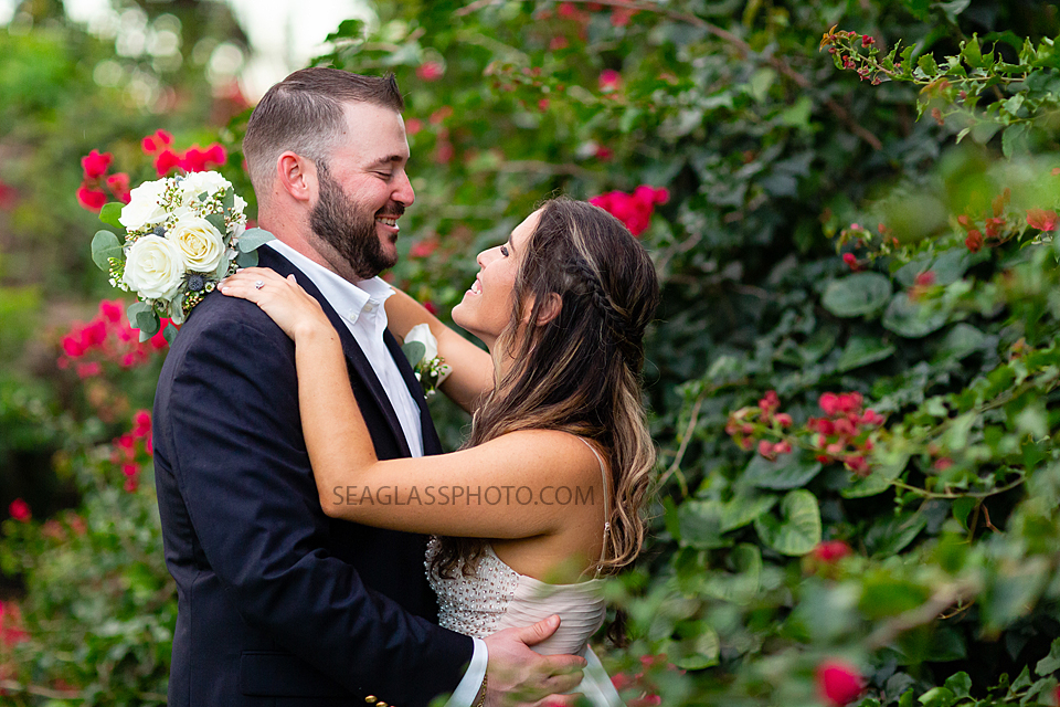 Bride and Groom looking lovingly at each other surrounded by flowers after their wedding in Vero Beach Florida