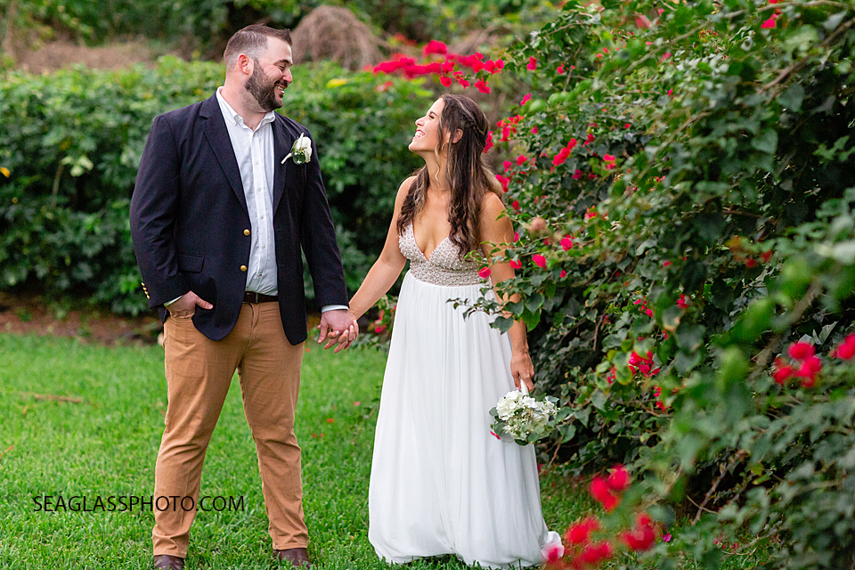 Bride and Groom laughing together among flowers after their wedding in Vero Beach Florida