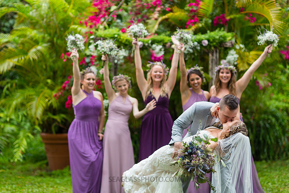 The Groom kisses his bride as the bridesmaids cheer them on in Vero Beach Florida