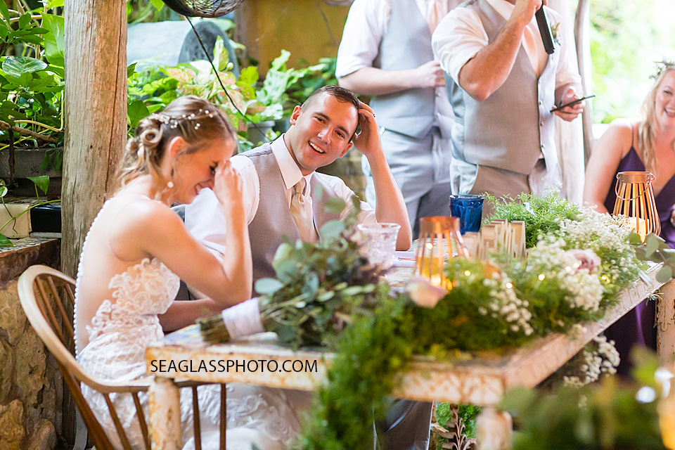 Bride and Groom laugh at their friend giving a speech during the reception in Vero Beach Florida
