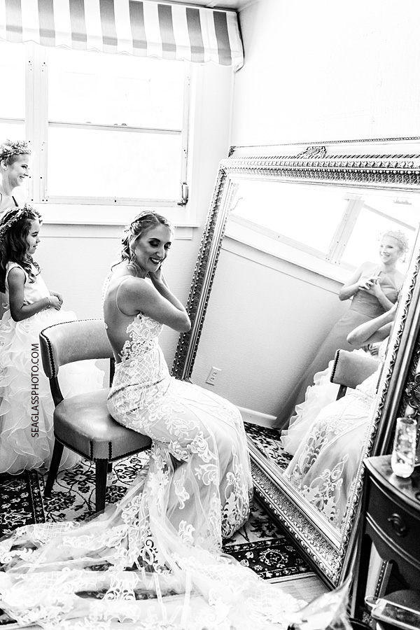 Black and white photo of the bride put on the final pieces of jewelry before the wedding in Vero Beach Florida