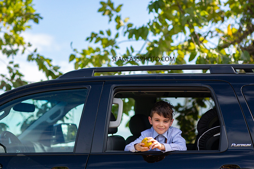 Brides son smiling for the camera in the back of a car in Vero Beach Florida