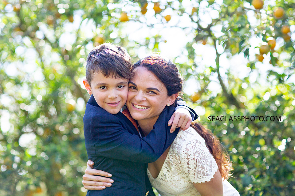 Brides son hugs her in an orange grove in Vero Beach Florida