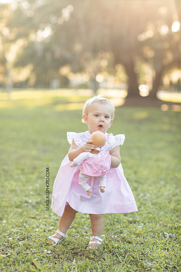 Adorable little girl playing with her doll in Riverside Park in Vero Beach Florida