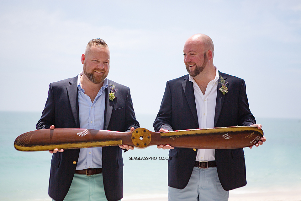 LGBT Grooms posing with a propeller on the beach in Vero Beach Florida