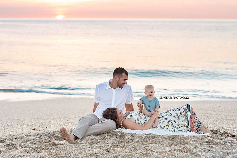 Couple laying with their baby on the beach at sunrise in Vero Beach Florida