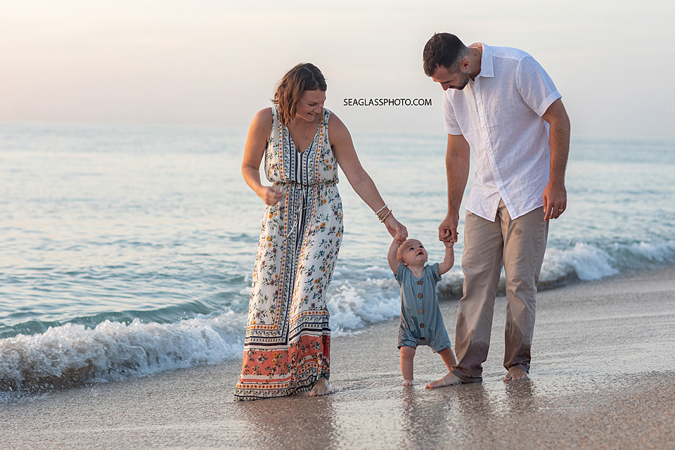 Parents walking with their son on the beach at sunrise in Vero Beach Florida