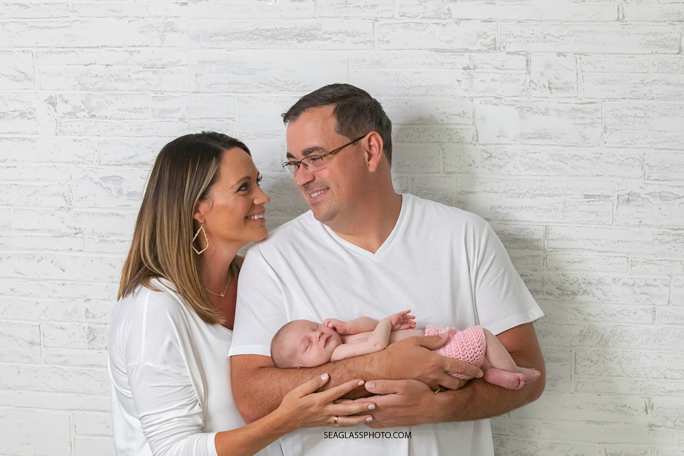 Parents holding beautiful baby girl newborn in Vero Beach Florida
