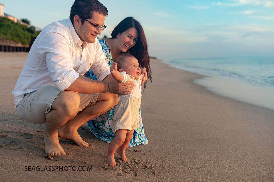 smiling baby with feet in the sand at colorful sunrise on the beach at Disney Vero Beach Resort by Seaglass Photography