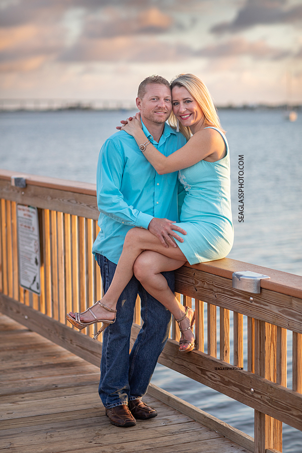 mom and dad couple sitting on a dock at sunset overlooking the Indian River at Riverside Park in Vero Beach Florida by Seaglass Photography