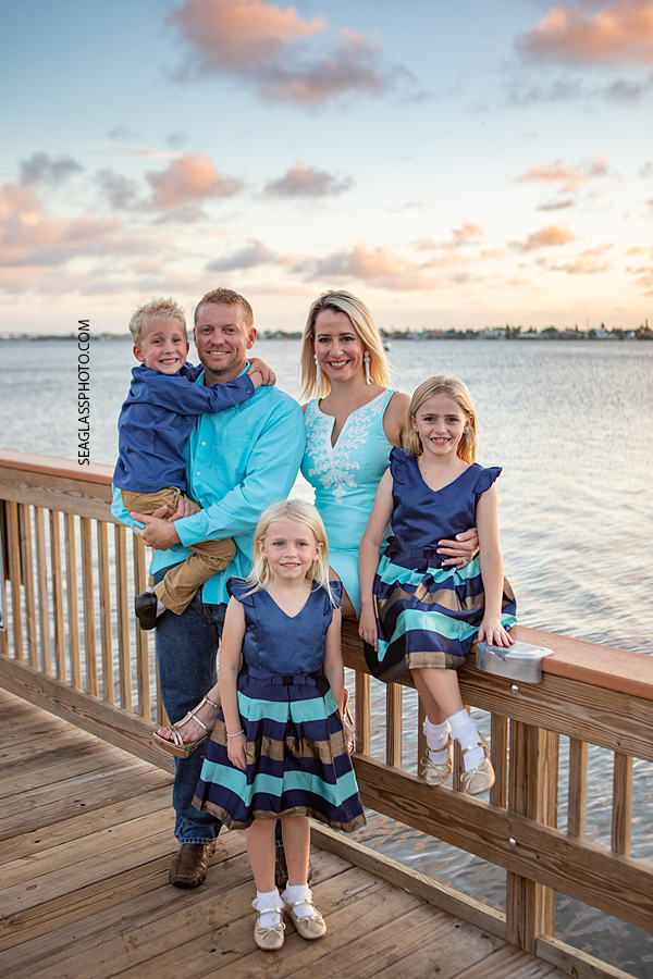 sunset photo of family on a dock in Vero Beach Florida wearing navy and aqua