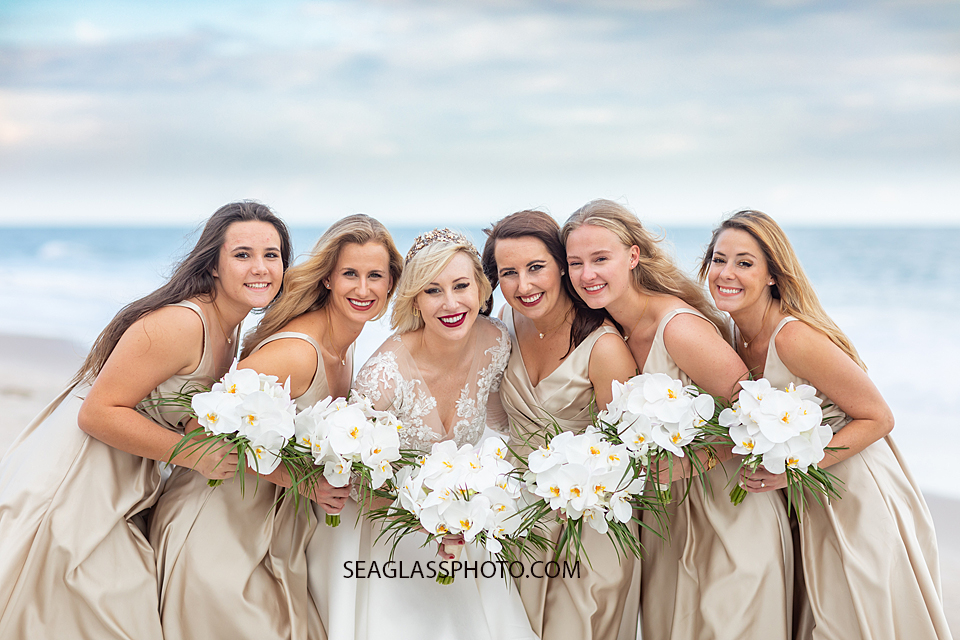 bride with her bridesmaids wearing gold on the beach with white orchids Wedding-CostadEste-Disney-Family-Vero-Beach-Photographer-Windsor