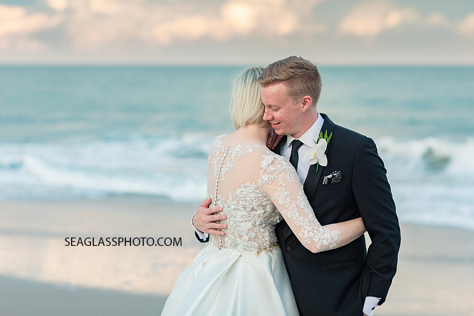 groom hugging onto his bride at sunset on the beach Wedding-CostadEste-Disney-Family-Vero-Beach-Photographer-Windsor-Seaglass