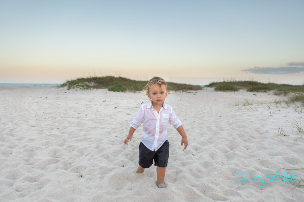 boy soaking wet walking on the beach at sunset Vero Beach Florida Newborn Photographer