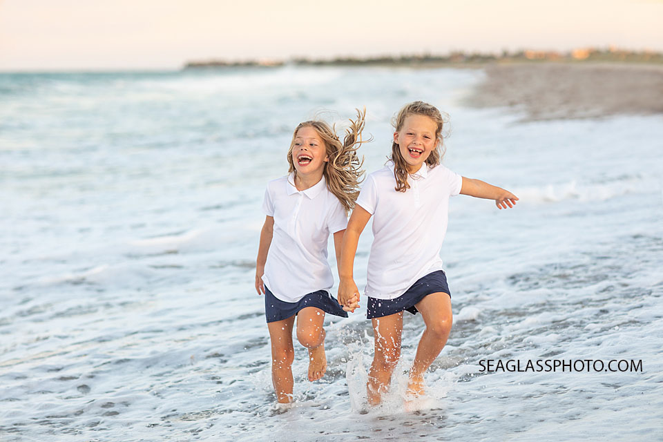 Vero Beach Family siblings playing in the water on the beach at sunset wearing navy and white 32963