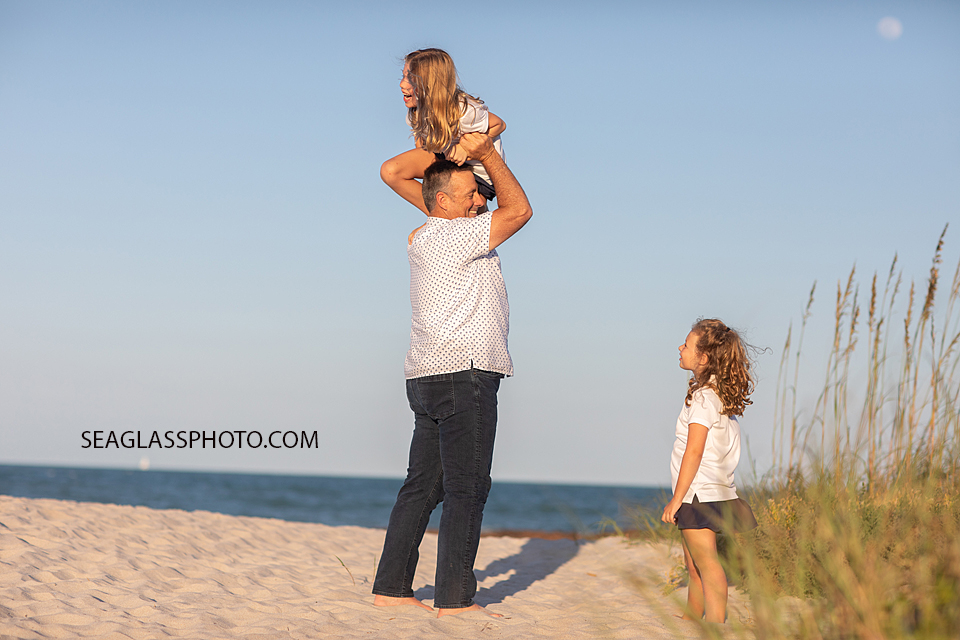 Father and daughters playing on the beach with a full moon. Vero Beach Florida 32963