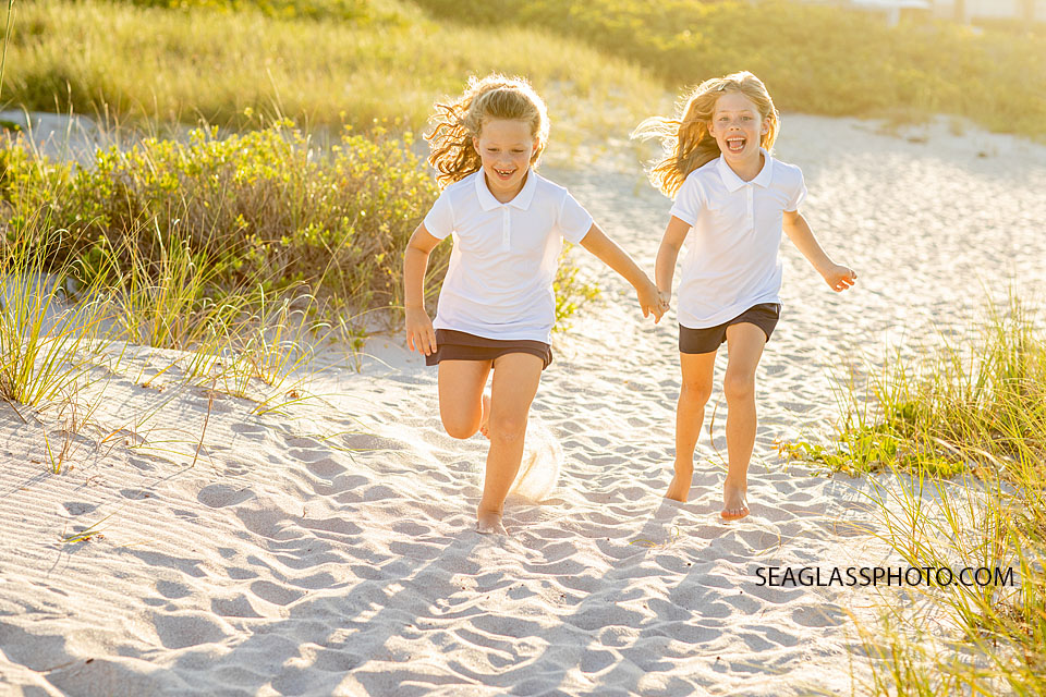 sisters running on the beach in the golden light Vero Beach Florida 32963
