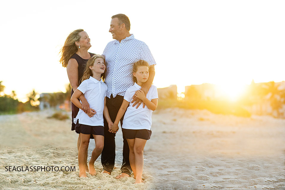 Family photo session standing on the beach holding hands. Wearing navy, white Vero Beach Florida
