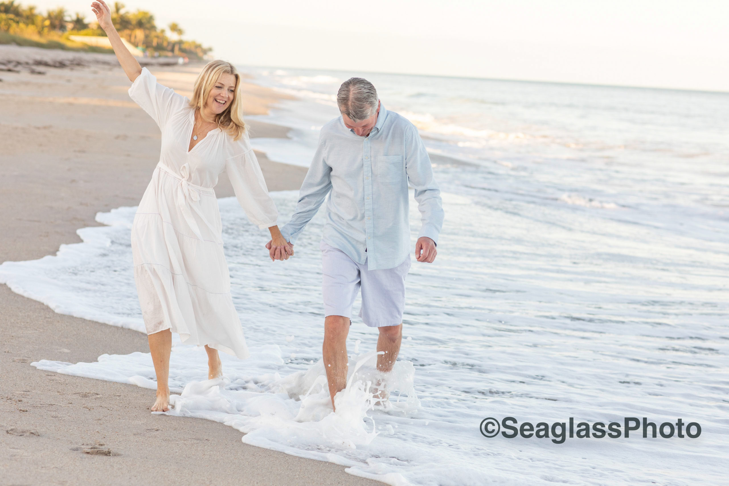 husband and wife couple walking along the shoreline in Vero Beach