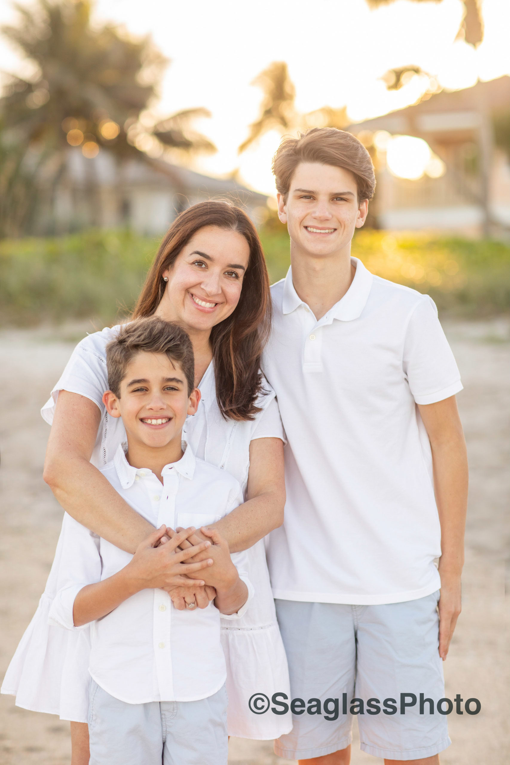 mother and two sons portrait with sunshine and palm trees