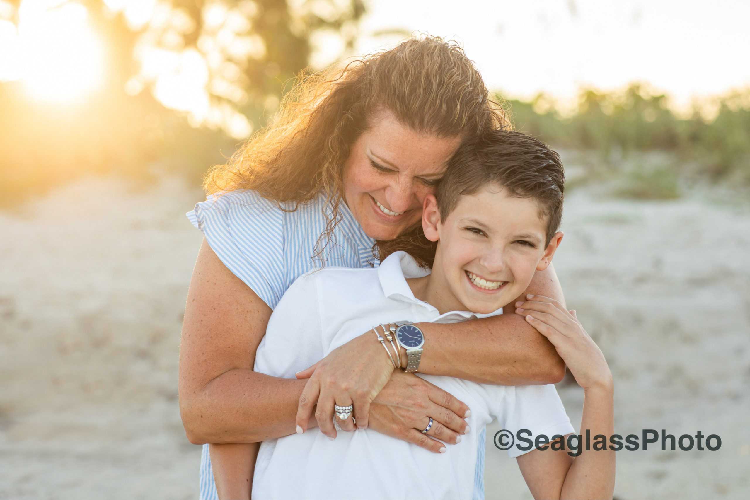 mom hugging onto her son on the beach with the sun shining Vero Beach