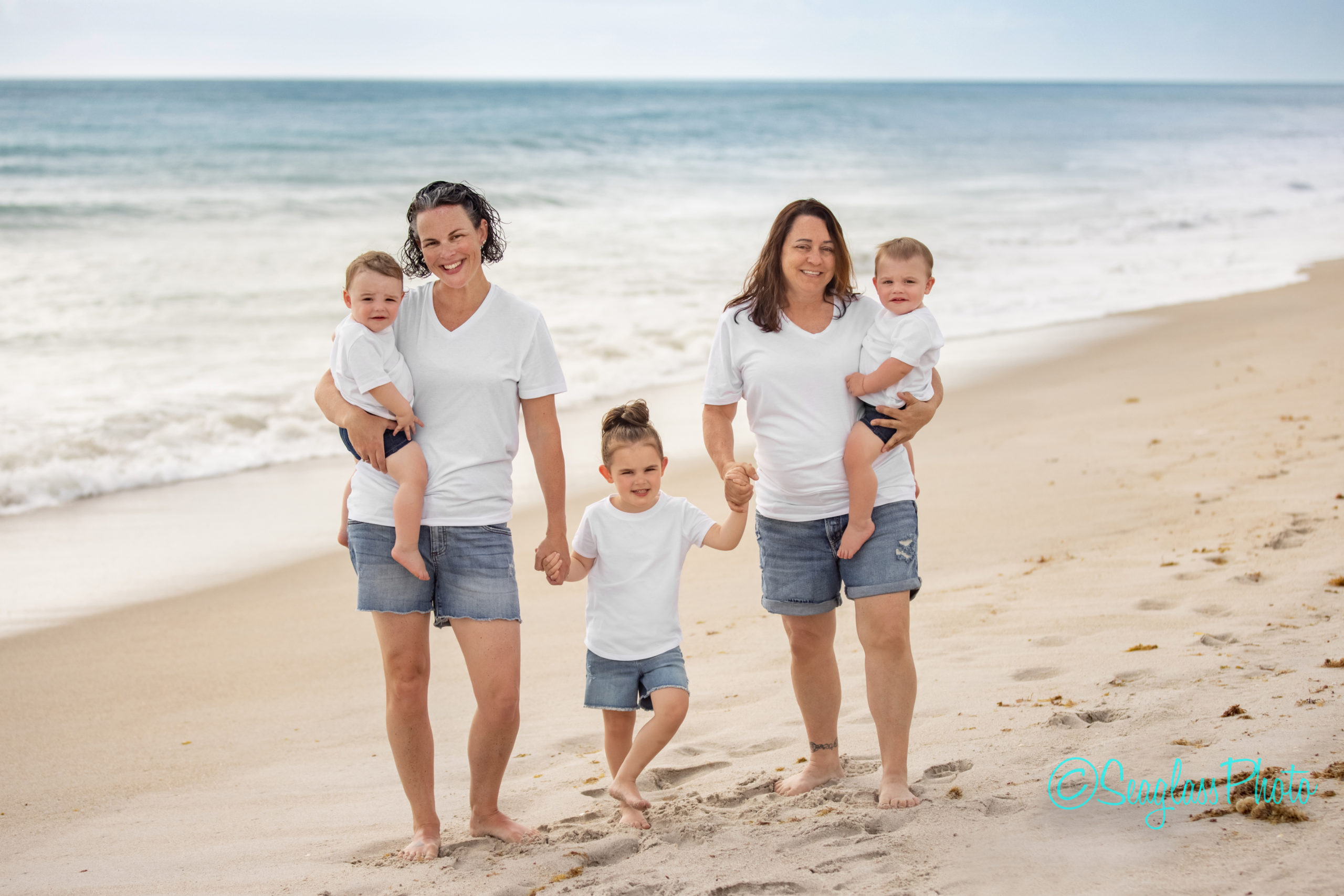 lesbian moms of twins wearing white and denim on the beach at Disney Vero Beach Hotel