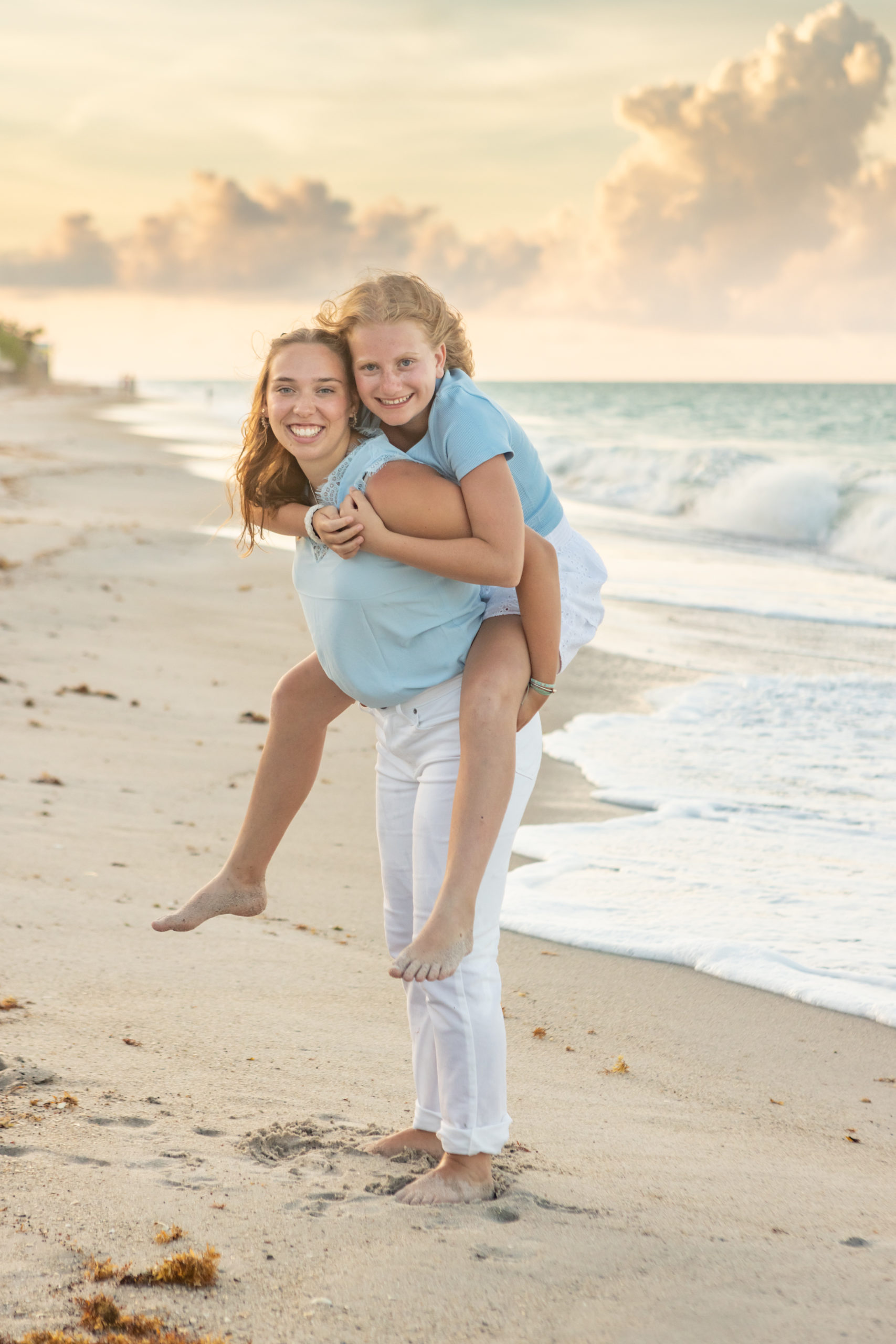 Portrait of sisters wearing white and blue on the beach at sunset in Vero