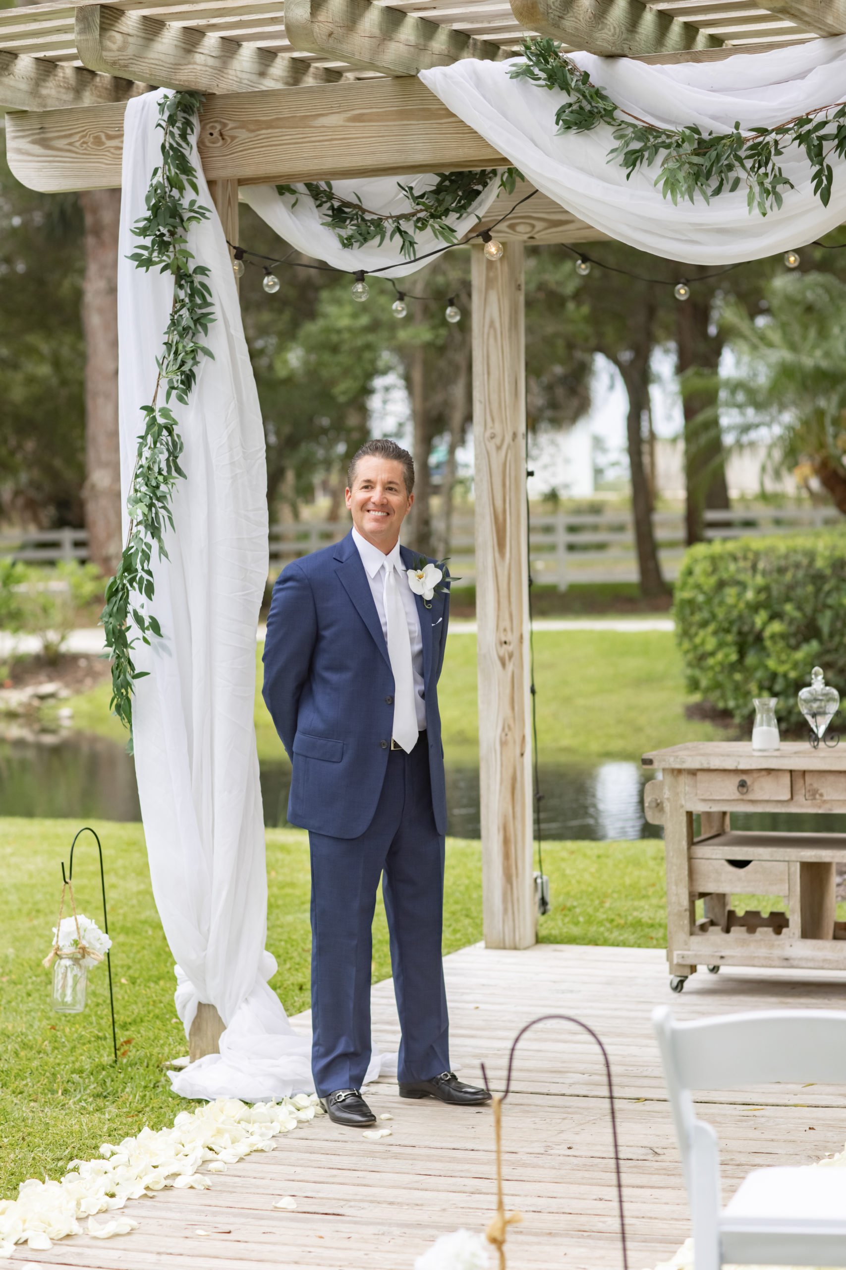 groom wearing a blue suit waiting for his bride at the alter  at Magnolia Manor in Vero Beach Fl 