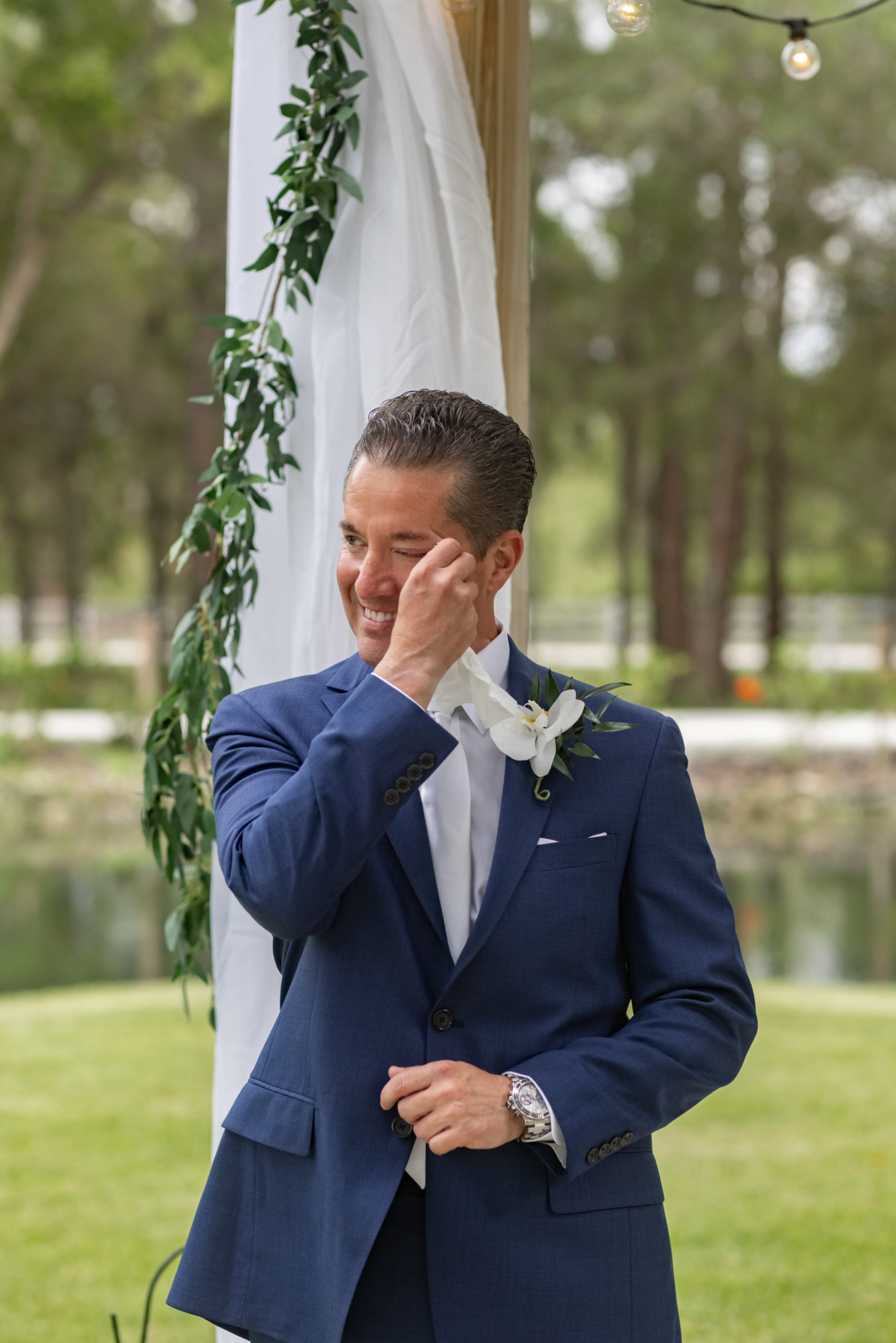 groom wiping away a tear while waiting for his bride to walk down the isle at Magnolia Manor in Vero Beach Fl 