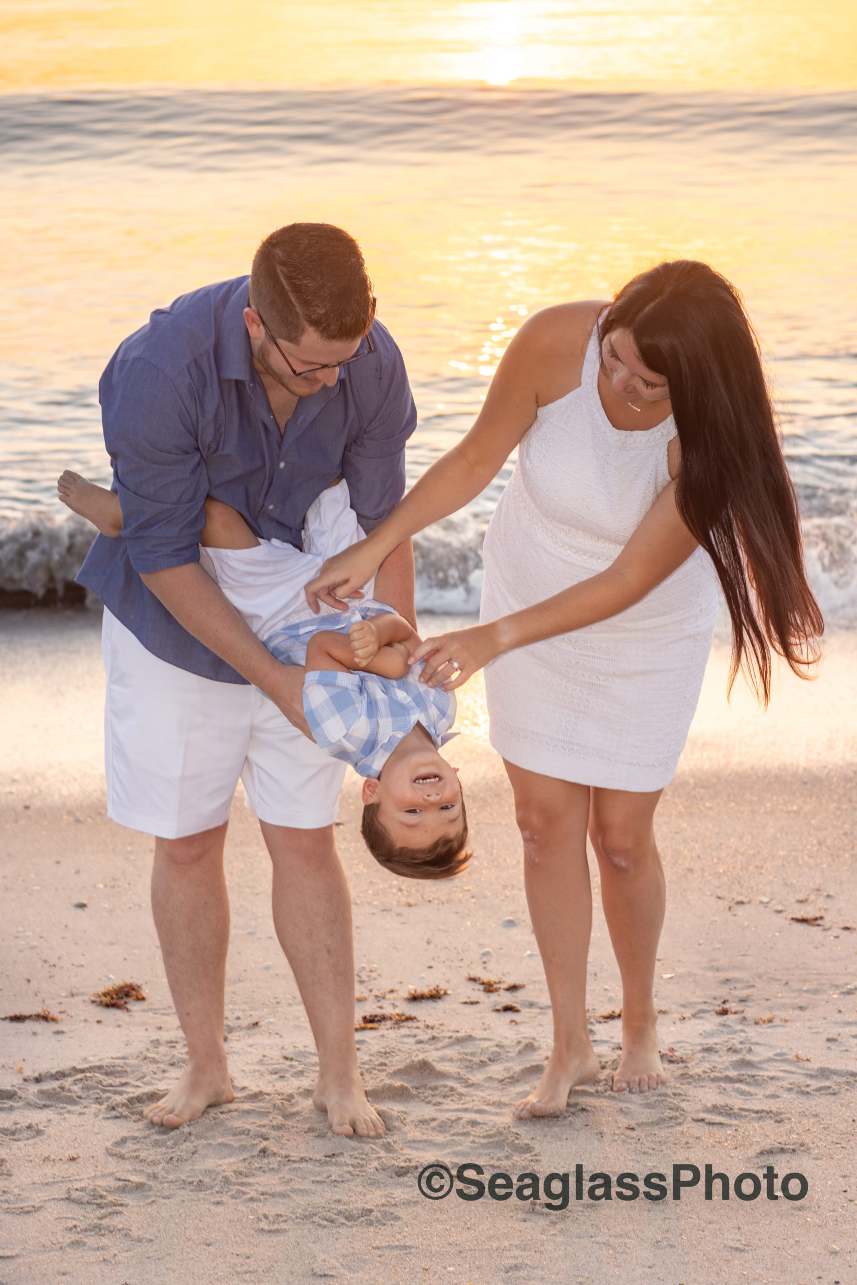 parents tickling their son on the beach at sunrise in Vero Beach Florida 
