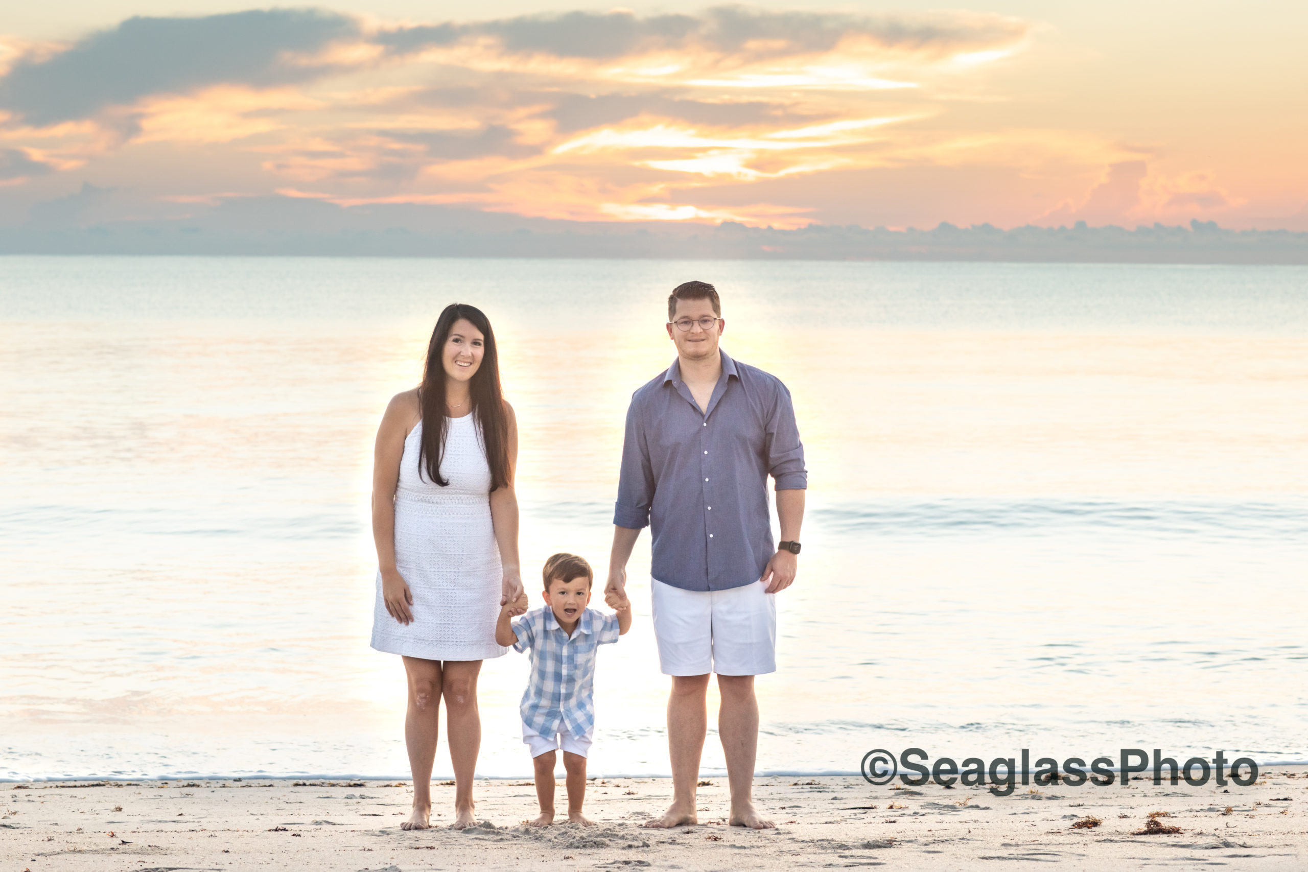 beautiful family portrait at sunrise with pink and yellow sky in Vero Beach Florida 