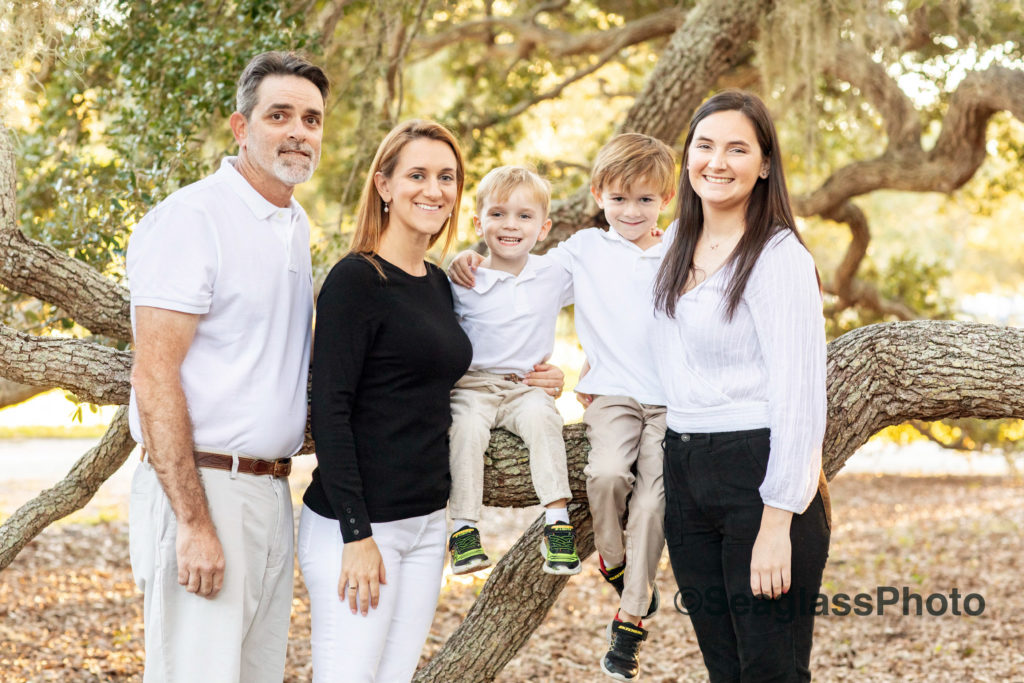 Boys sitting in an oak tree for family photos wearing black and white