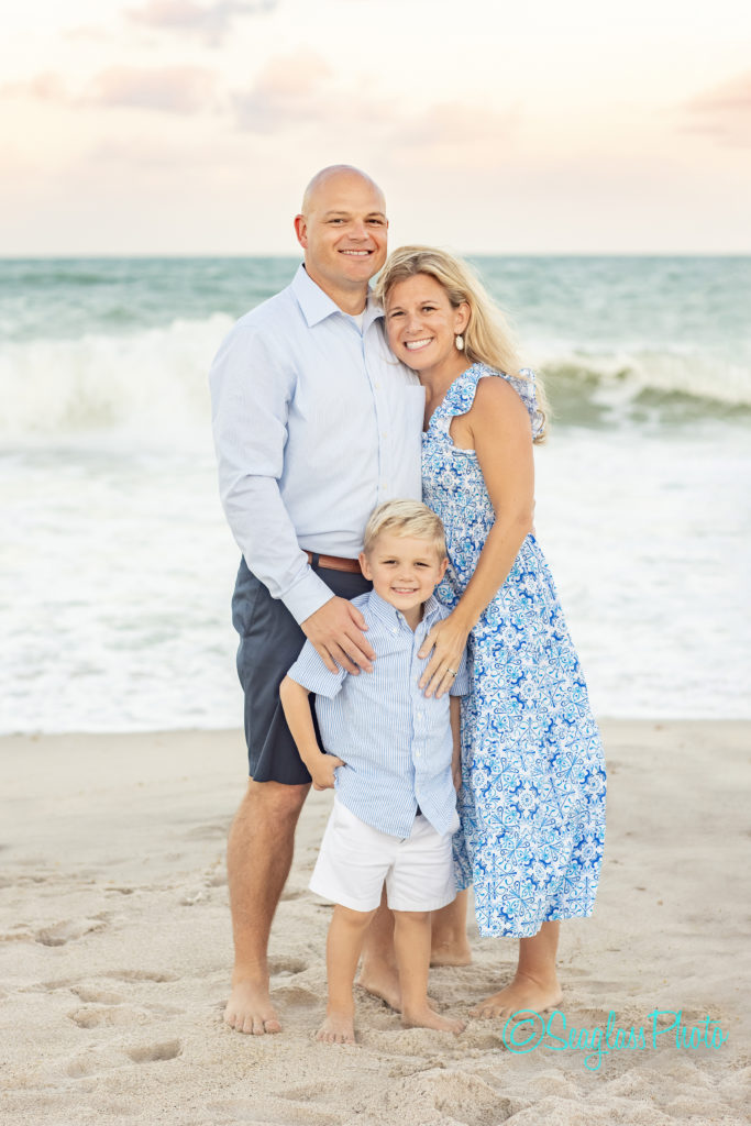 Adorable family of 3 standing in front of the ocean at sunset in Vero Beach Florida 