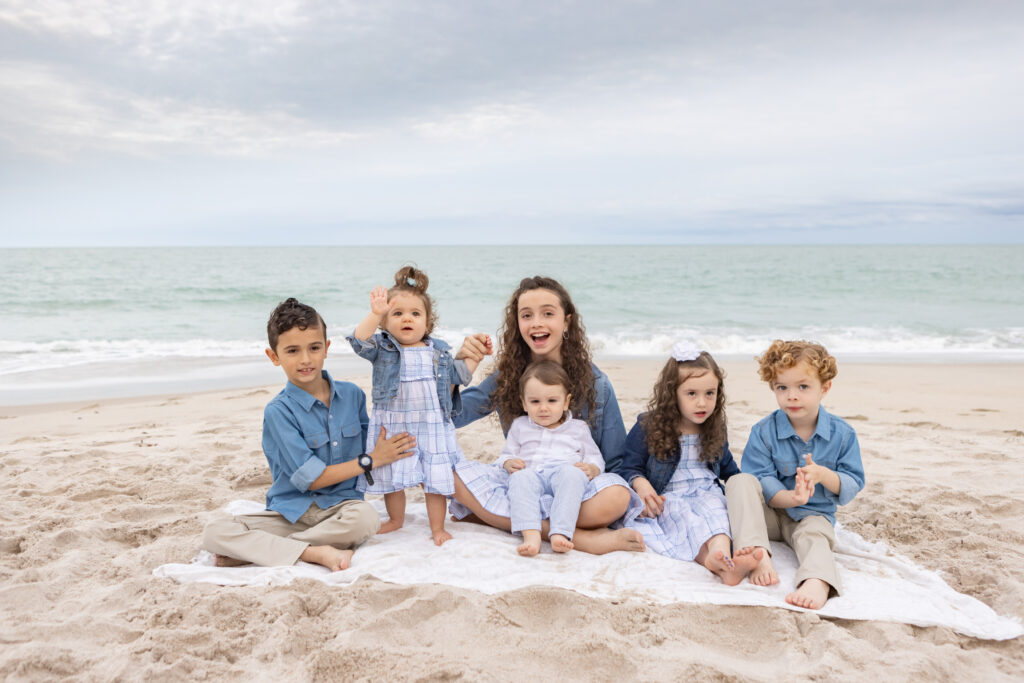 six kids sitting on the beach Vero Beach, Florida 32966 smiling and laughing
