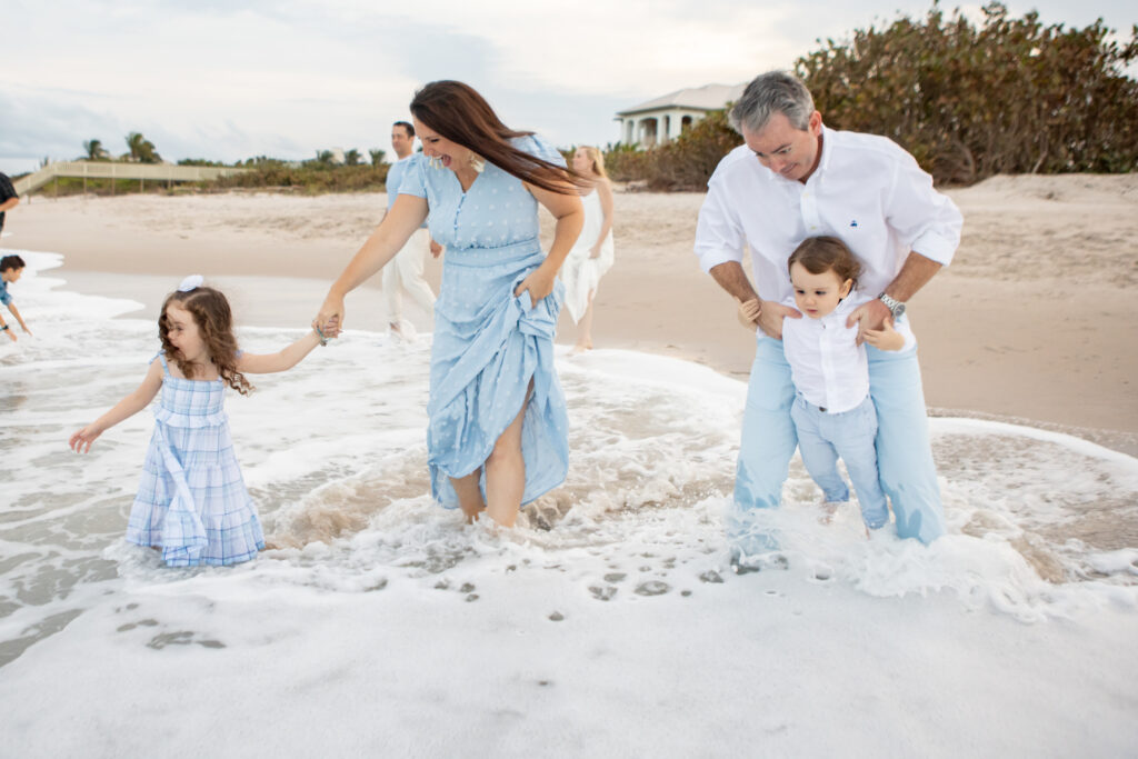 crashing waves onto a family holding hands