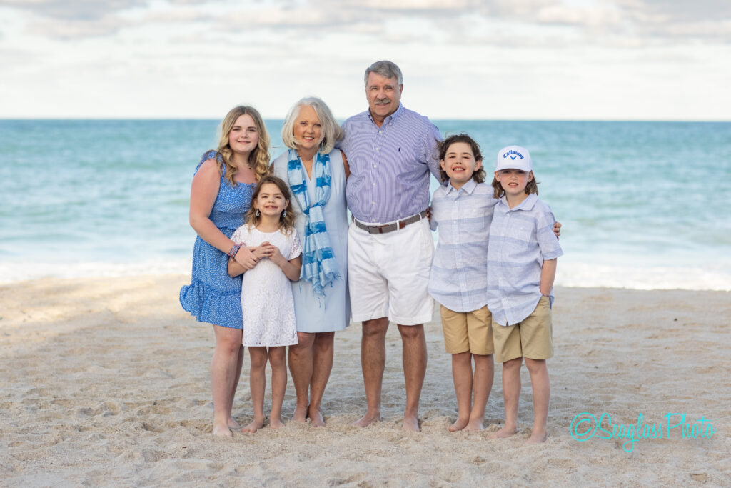 grandparents on the beach with grandkids wearing blue and white at Grand Harbor Beach Club in Vero Florida 