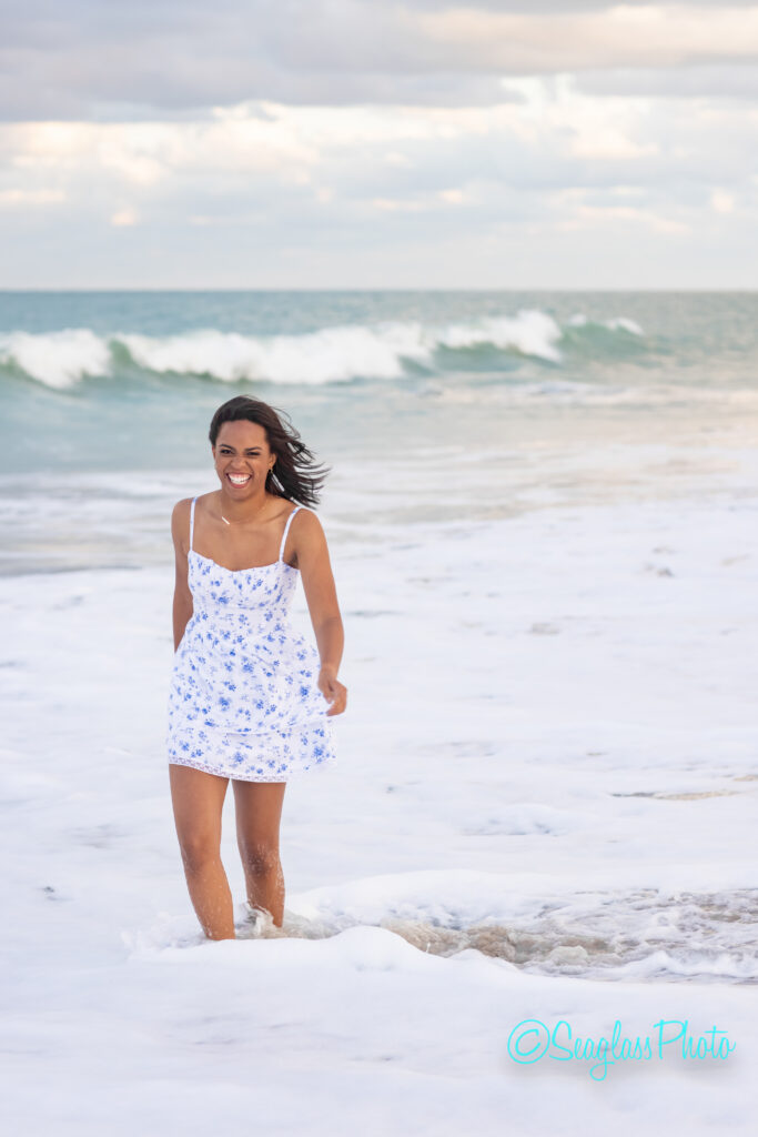 high school senior laughing with the waves in Vero Beach Fl 