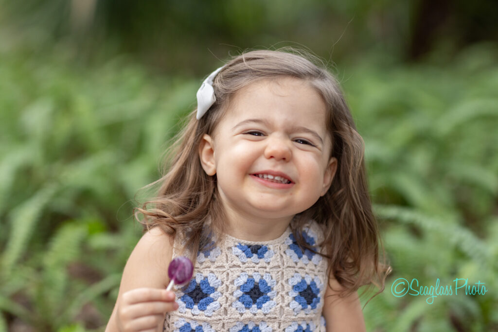 portrait of a toddler girl holding a purple lolipop in Vero Beach Florida