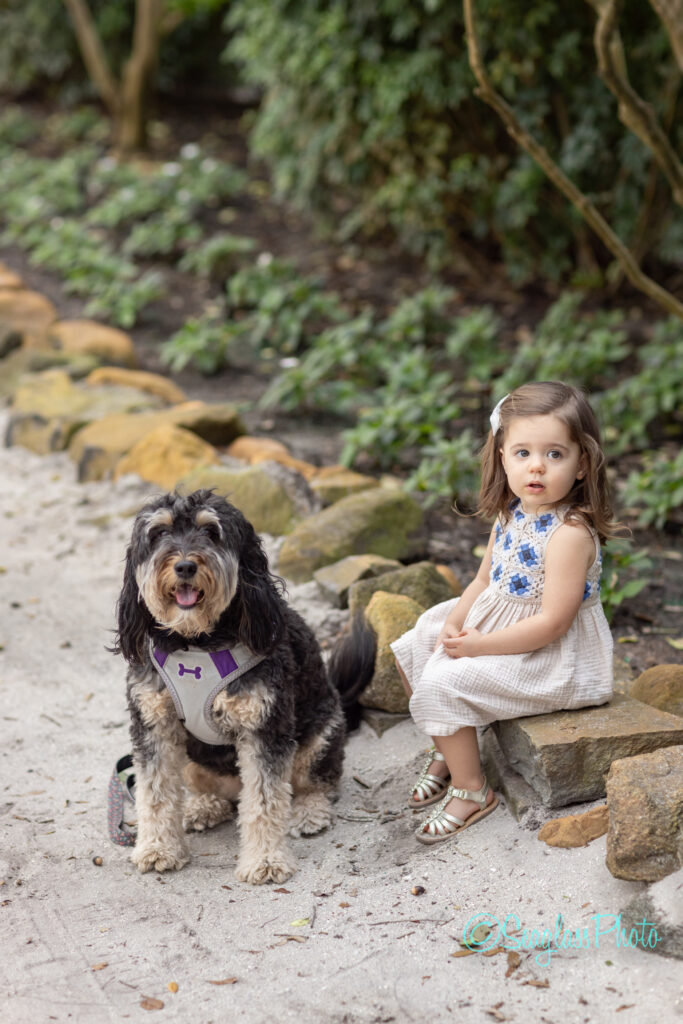little girl with her dog sitting on a rock in Vero Beach Florida