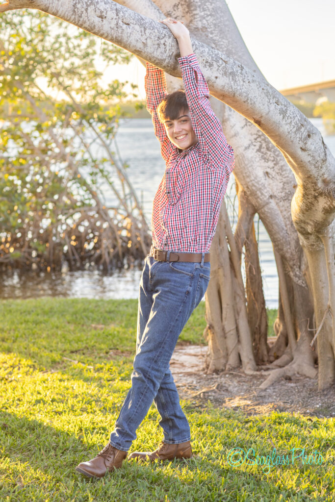 fun portrait of a teen hanging from a tree by the river in Vero Beach Florida 