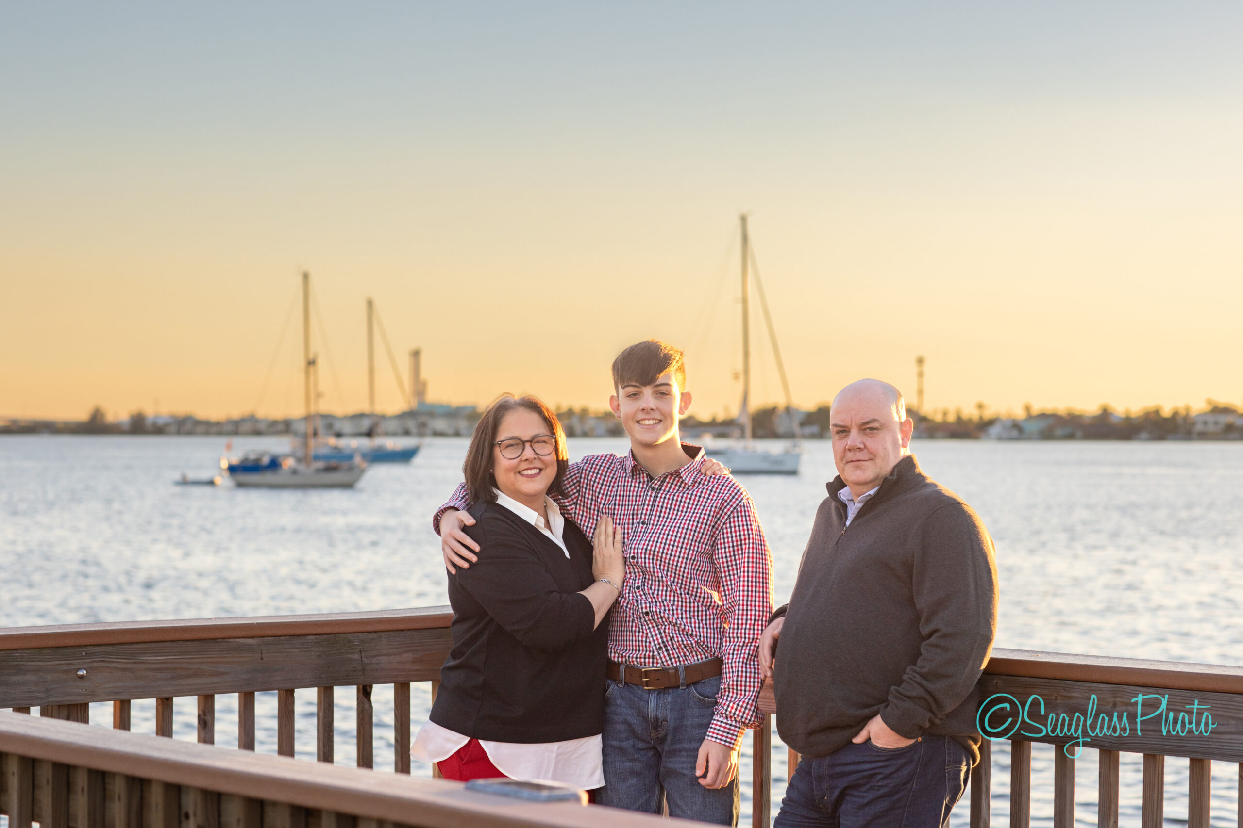 Beautiful sunset portrait of a Vero Beach family by the Indian River with sailboats in the background
