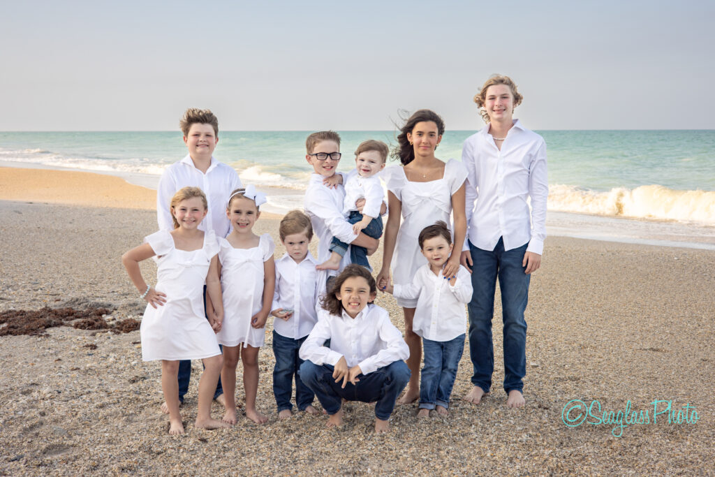 formal photo of grandkids on the beach wearing white and jeans in Vero Beach Florida 