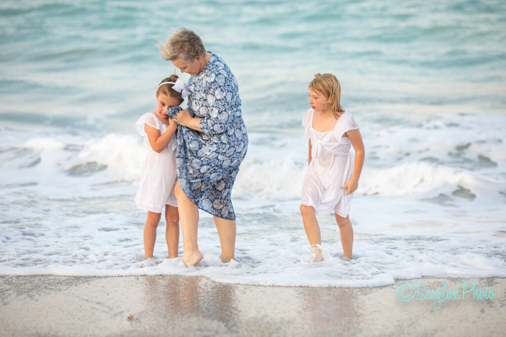 grandmother comforting her granddaughter from the crashing waves 