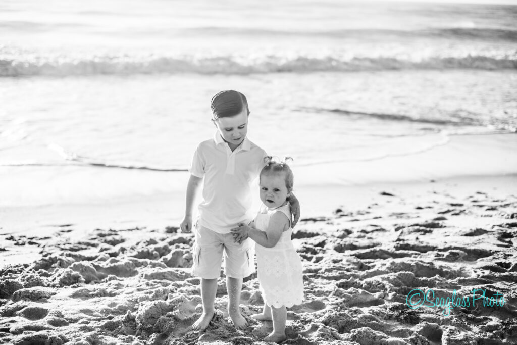 black and white family photo of siblings on the beach 