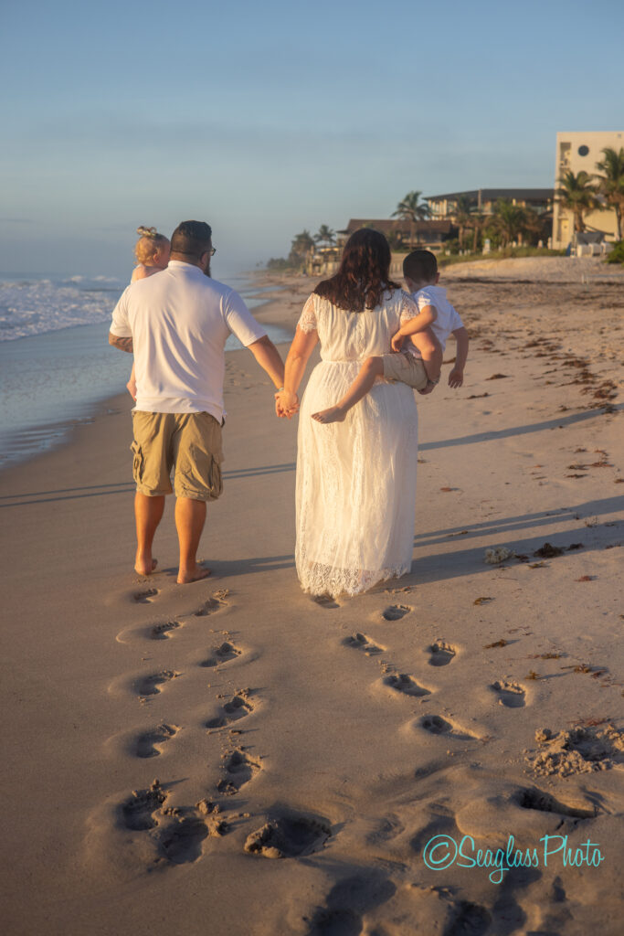 family walking on the beach in front of Costa D'Este in Vero Beach Florida 