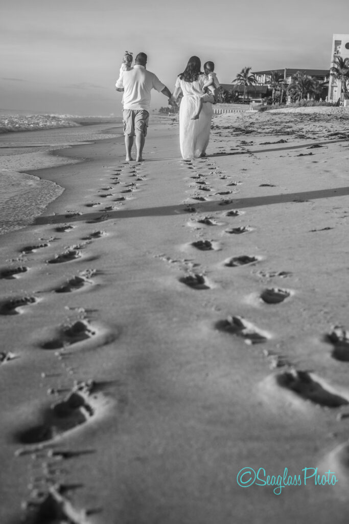 black and white photo of footsteps in the sand during a family photoshoot in Vero Beach Fl. 