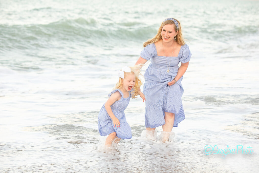 mother and daughter wearing blue dresses playing in the ocean  Disney Vero Beach Resort 