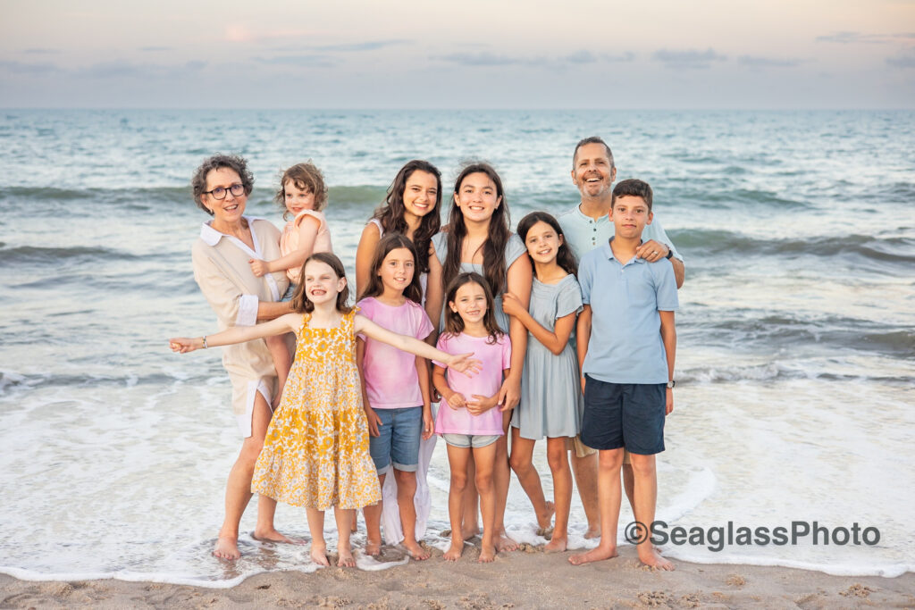 grandparents with grandkids by the ocean with water splashing on the feet